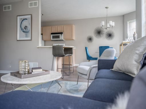 a living room with a couch and a table and a kitchen