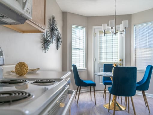 a kitchen and dining room with a stove and a table and chairs