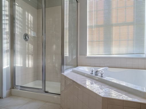 a bathroom with a tub and a shower and a sink