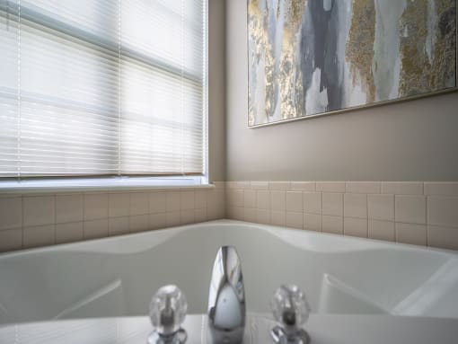 a bathroom with a bath tub and two windows