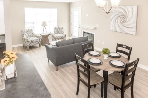 a living room and dining room with a table and chairs