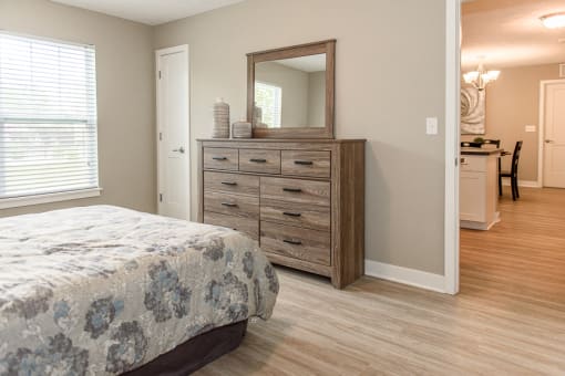 a bedroom with a bed and a dresser with a mirror