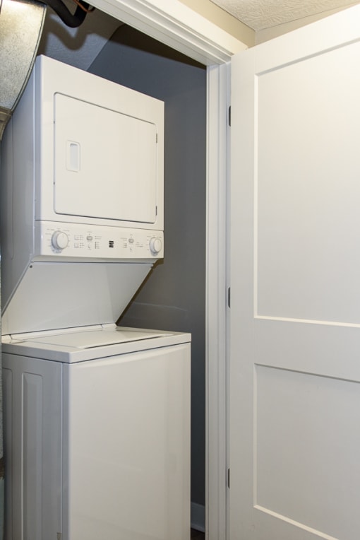 a white washer and dryer in a room next to a door