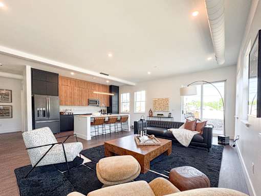 Typical great room with doors to private patio, kitchen with GE Profile appliances, and kitchen island with breakfast bar.