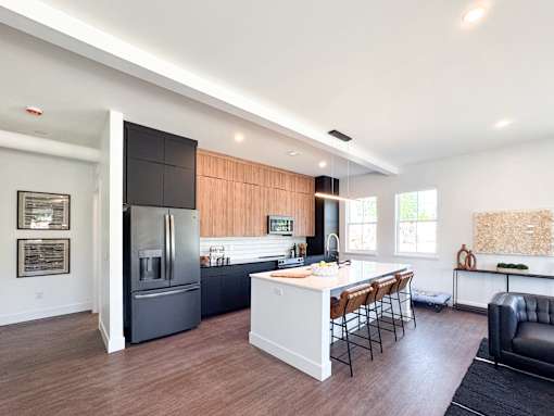 A modern kitchen with a refrigerator, stove, and island.
