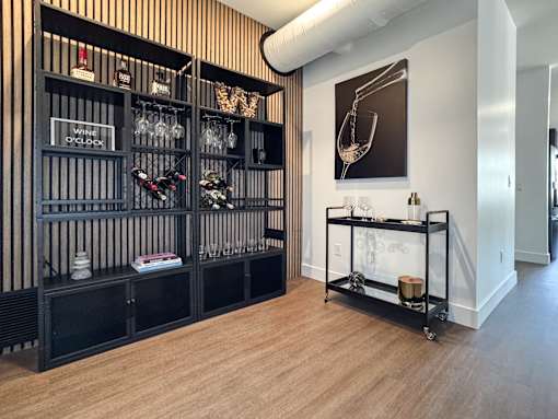 A wine rack with bottles and glasses on it.