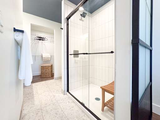 A bathroom with a walk in shower and a towel rack.