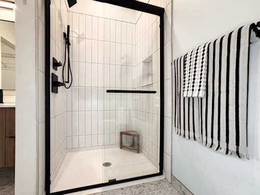 A white tiled bathroom with a walk in shower.