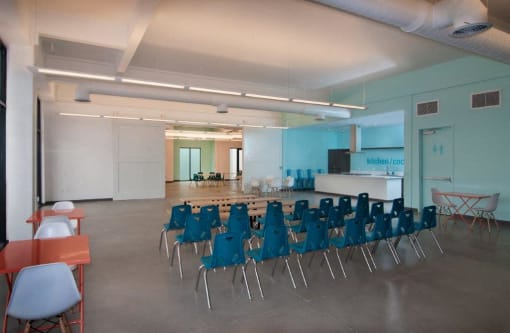 a large room with blue chairs and a table