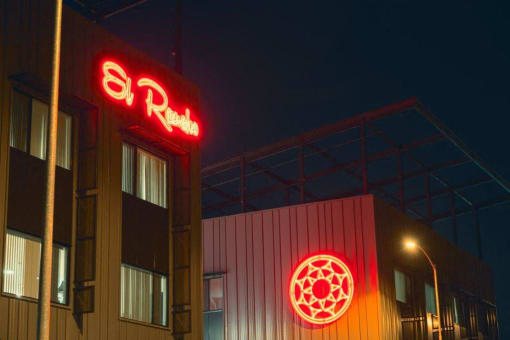 a red neon sign on the side of a building