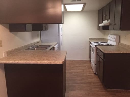 an empty kitchen with a stove and a sink