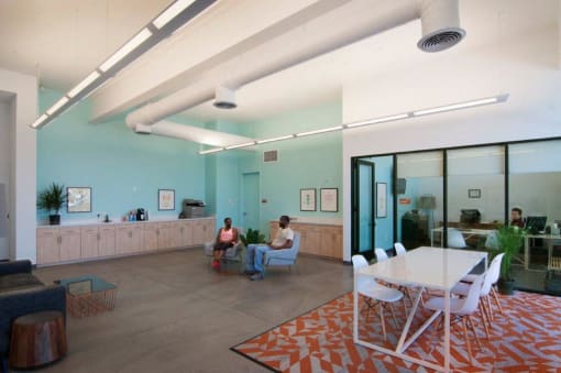 people sitting in a room with a white table and chairs