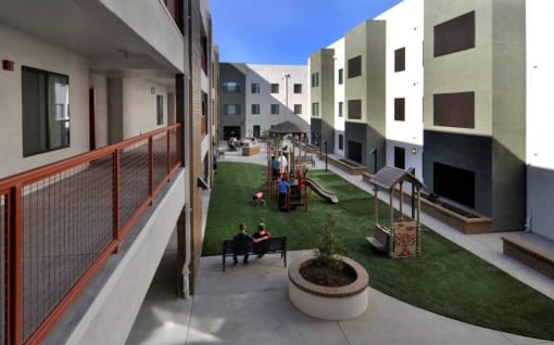 people sitting on benches in a courtyard between buildings