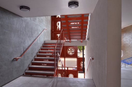 the stairs in a building with a car mural on the wall