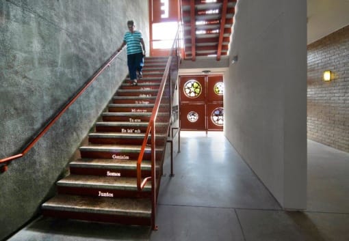 a boy is walking up the stairs in a building