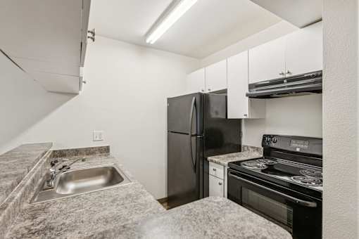 A kitchen with a granite countertop and stainless steel appliances.