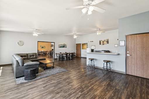 A living room with a couch, chairs, and a bar area.