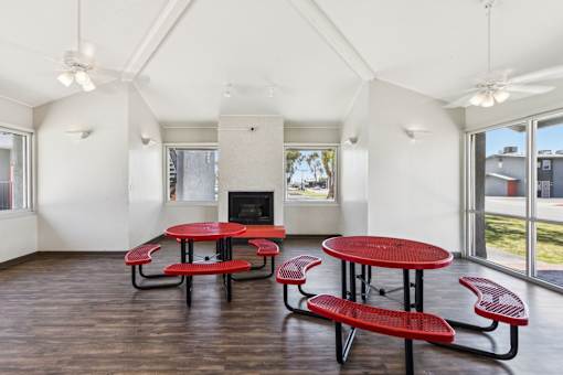 A room with tables and chairs and a fireplace.