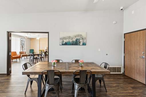 A dining room with a wooden table and chairs.