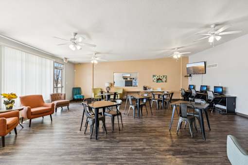 A room with a table and chairs and a television.