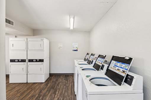 A row of washing machines are lined up in a laundromat.