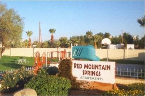 a red mountain springs park with a playground and a sign