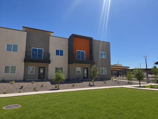 A modern building with a mix of grey and orange panels.