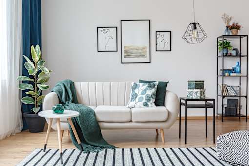 a living room with a white couch and green pillows