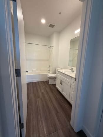 A bathroom with a toilet, sink, and bathtub.