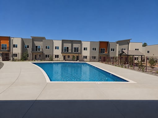 A swimming pool in front of a row of houses.