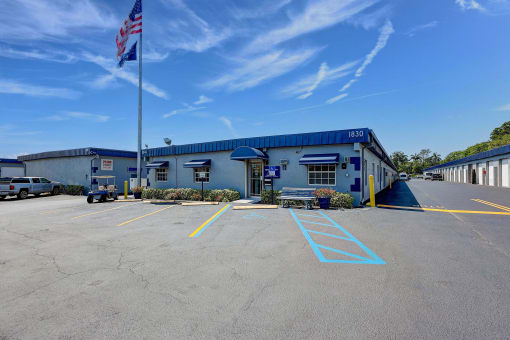 an empty parking lot in front of the HEG office building with an american flag