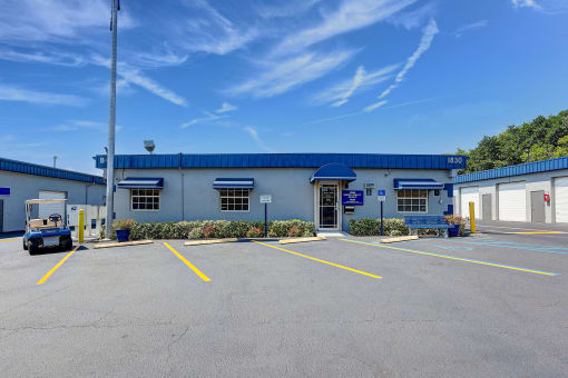 an empty parking lot in front of a building with a blue roof
