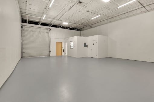 a large empty room with white walls and a door in the middle