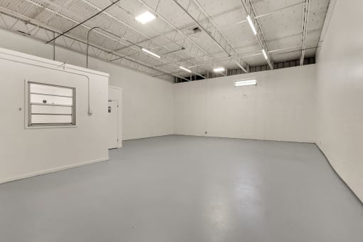 the interior of an empty room with white walls and a window