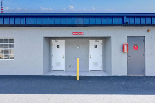 the outside of a building with three doors and a red fire hydrant