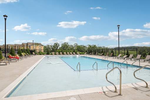 A large outdoor swimming pool with a metal ladder on the side at Venue at 109 Apartments, Lebanon  37090