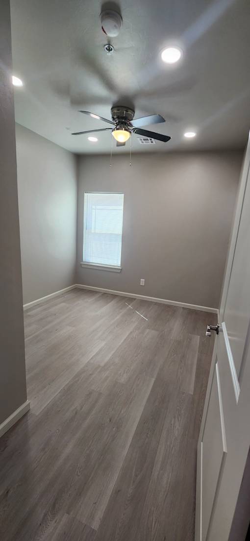 A room with a ceiling fan and a window.