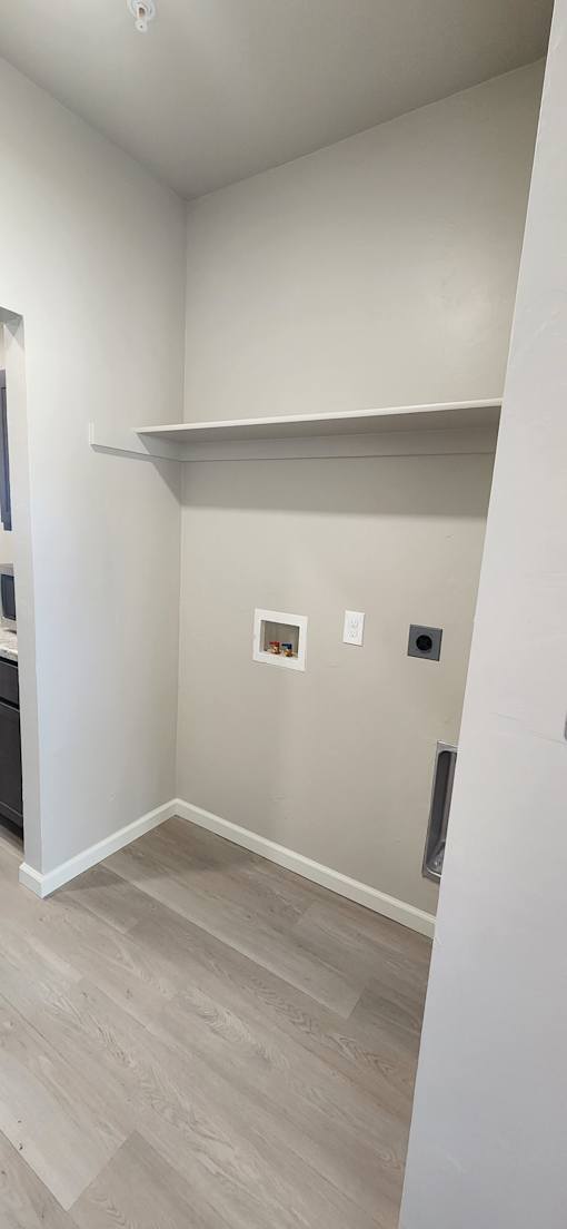 A white kitchen with a wooden floor and a white ceiling.