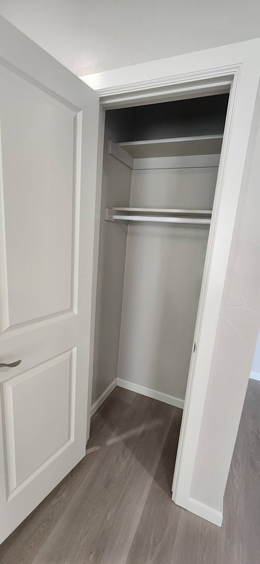 A white cabinet with a door open revealing shelves inside.
