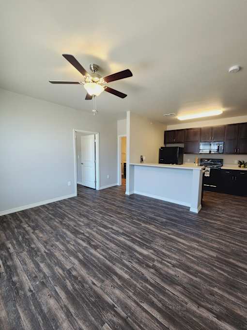 A ceiling fan hangs over a white counter in a room with a wood panel wall.