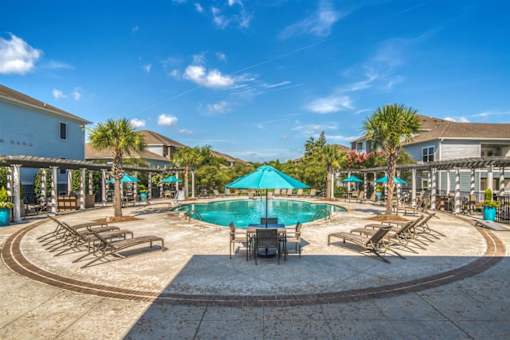 A large swimming pool surrounded by lounge chairs and umbrellas.