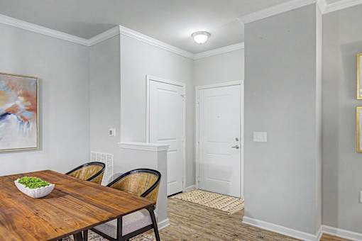 A dining room with a wooden table and chairs.