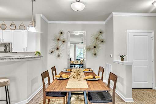A dining room with a wooden table set for a meal.
