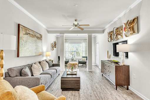 A living room with a grey couch and a wooden coffee table.