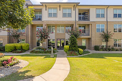 A building with a green lawn in front.