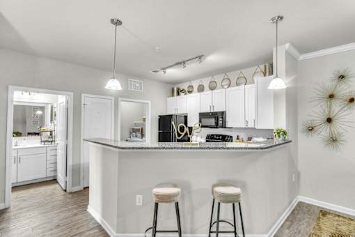 A kitchen with a bar area and two stools.