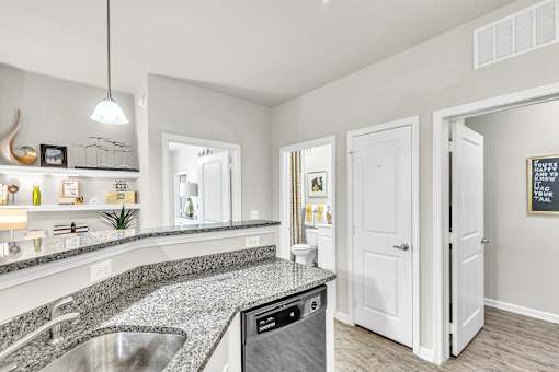 A modern kitchen with a granite countertop and stainless steel appliances.