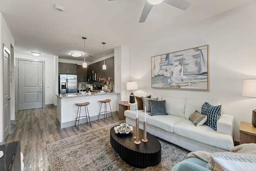 A modern living room with a bar area and a painting on the wall.