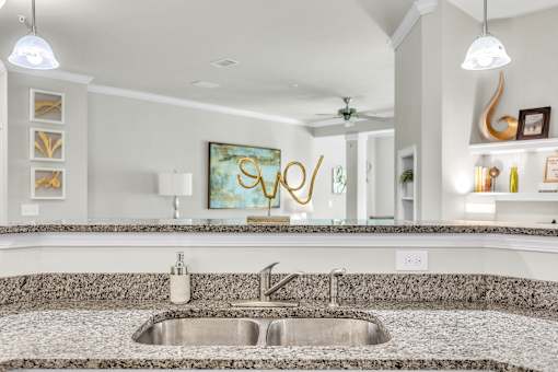 A modern kitchen with a granite countertop and a sink.