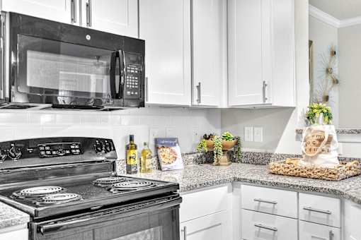 A black stove top oven with a black microwave above it.